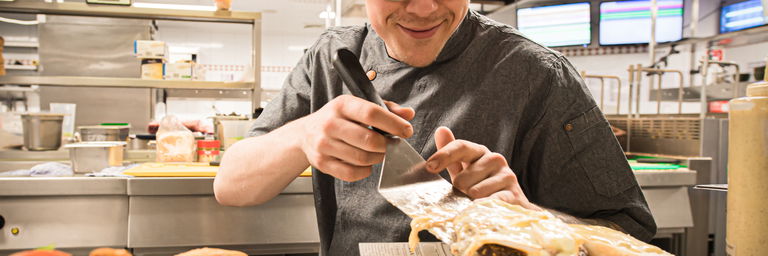 Kok in de keuken die een maaltijd klaarzet