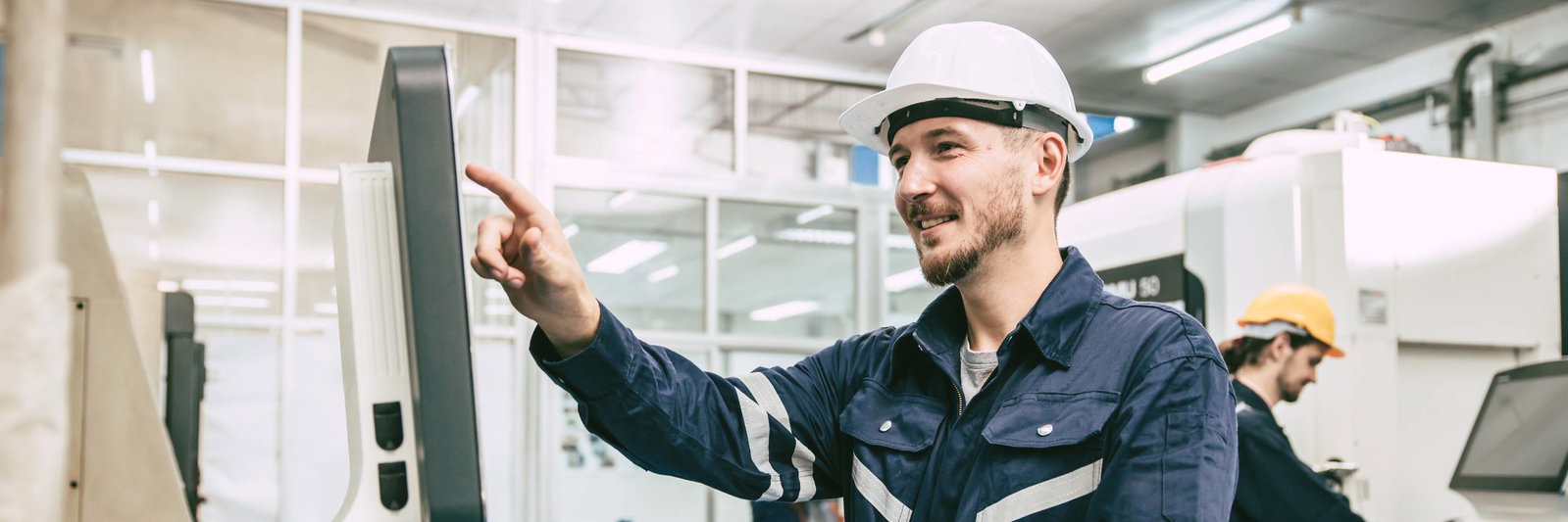 Engineer in a factory looking at a machine