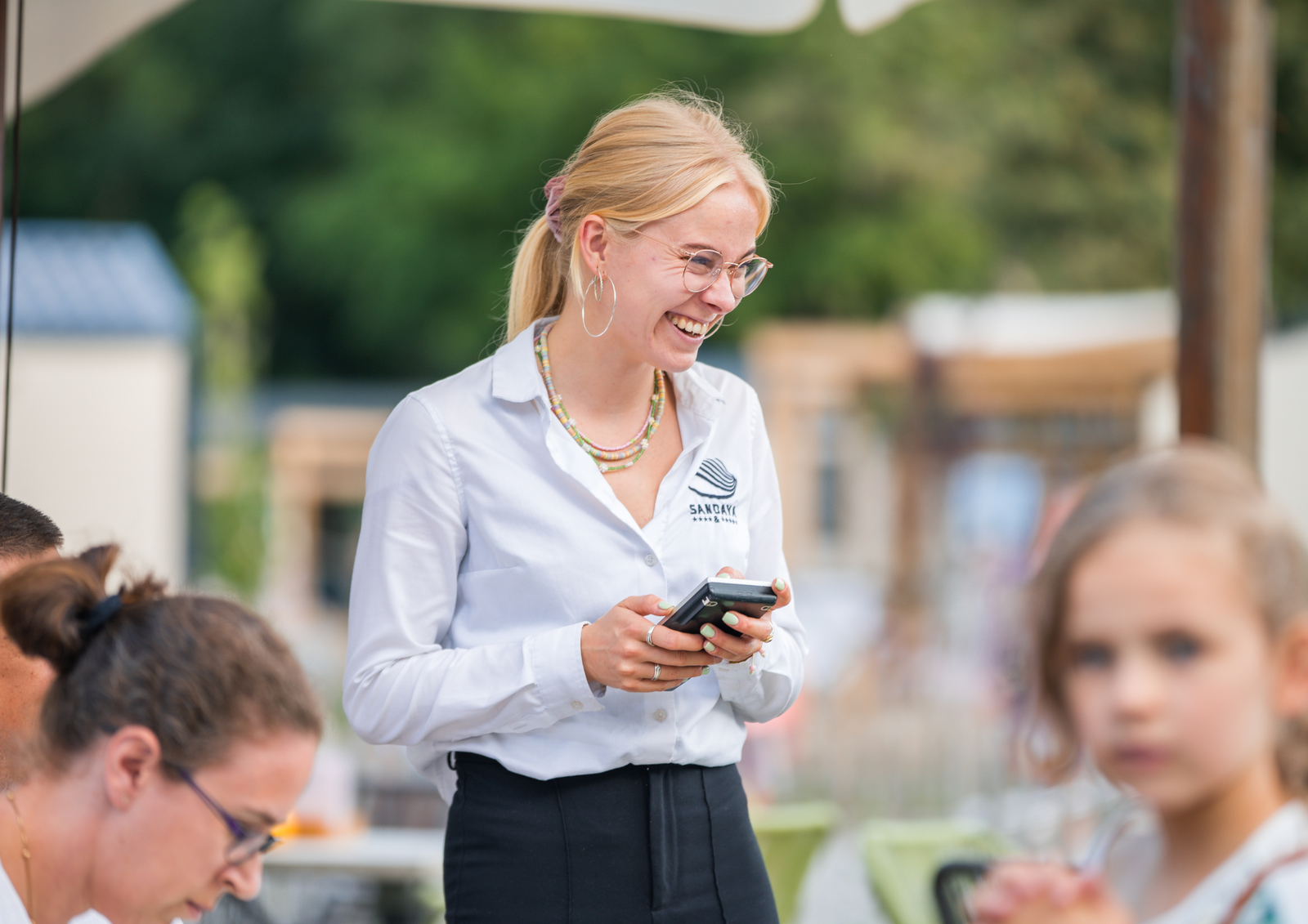 Medewerkster neemt bestelling op op een terras