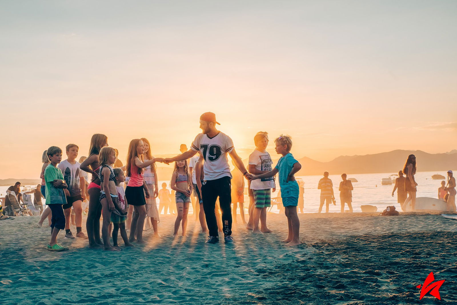 Camp-Entertainer mit Kindern am Strand