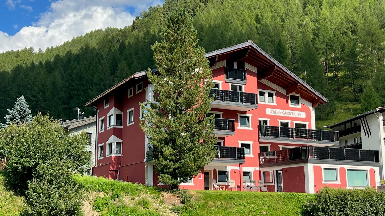 Blick auf ein Hotel in der Schweiz an einem Sommertag
