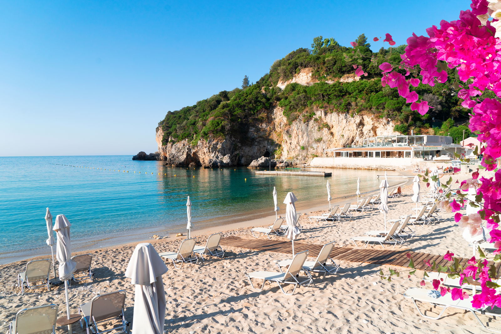 Strand mit Sonnenschirmen, Stühlen und Blumen