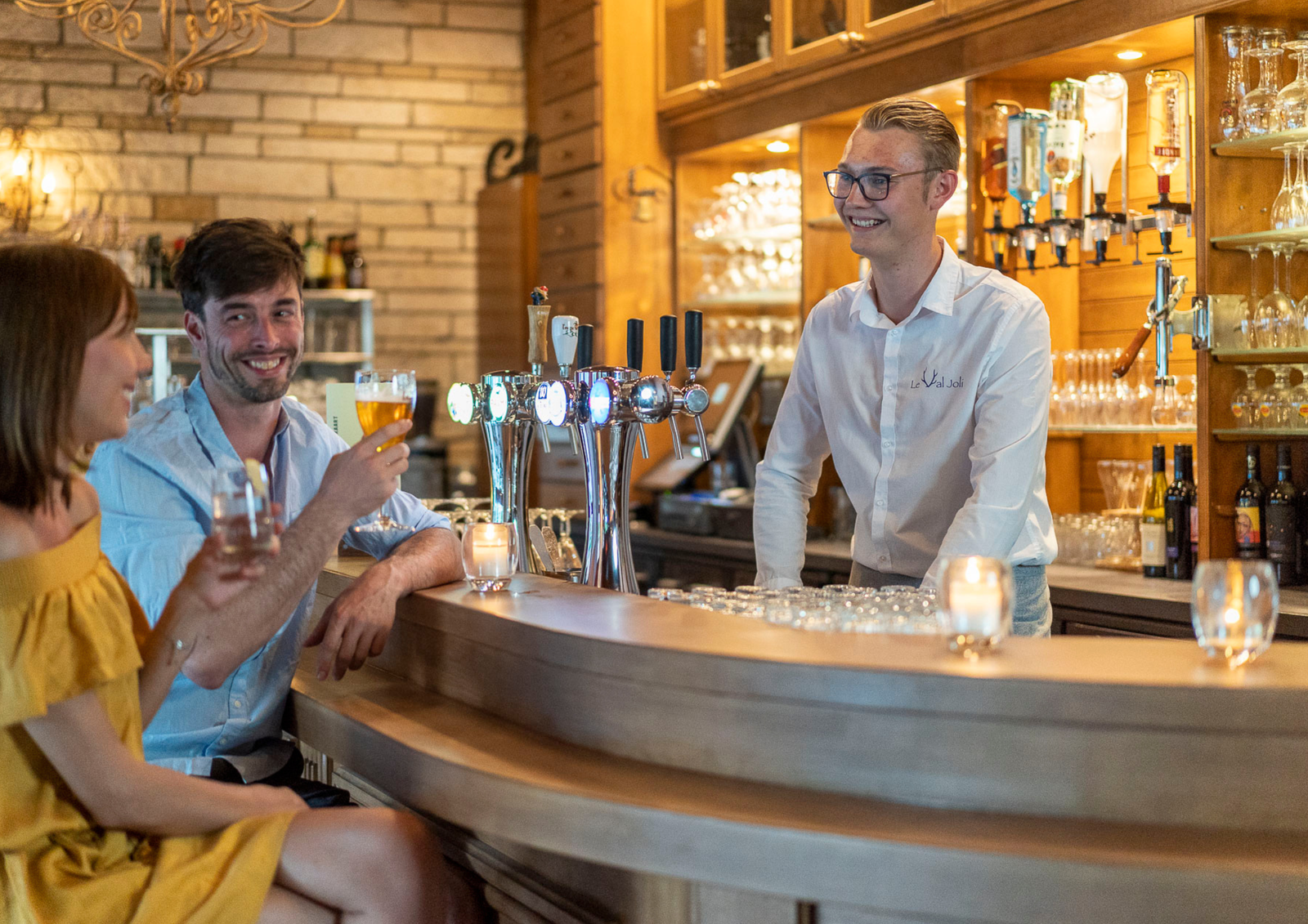 Barmedewerker in bar met gasten aan de bar