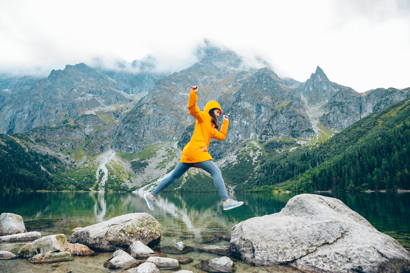 Woman jumping on rocks in Poland