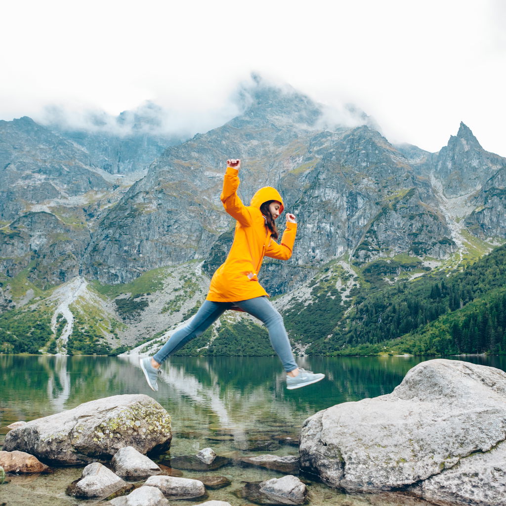 Woman jumping on rocks in Poland