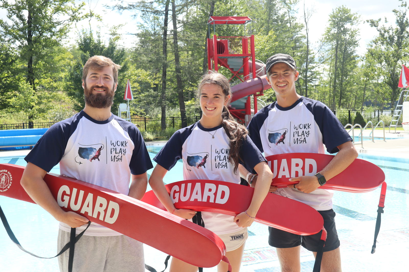 Drie medewerkers van een summercamp met een reddingsboei