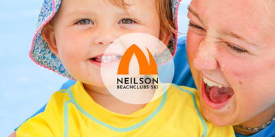 Kinderactiviteitenbegeleidster met een kind op het strand