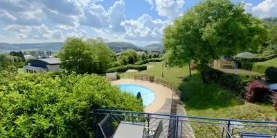 Overzicht van een camping met zwembad en natuur