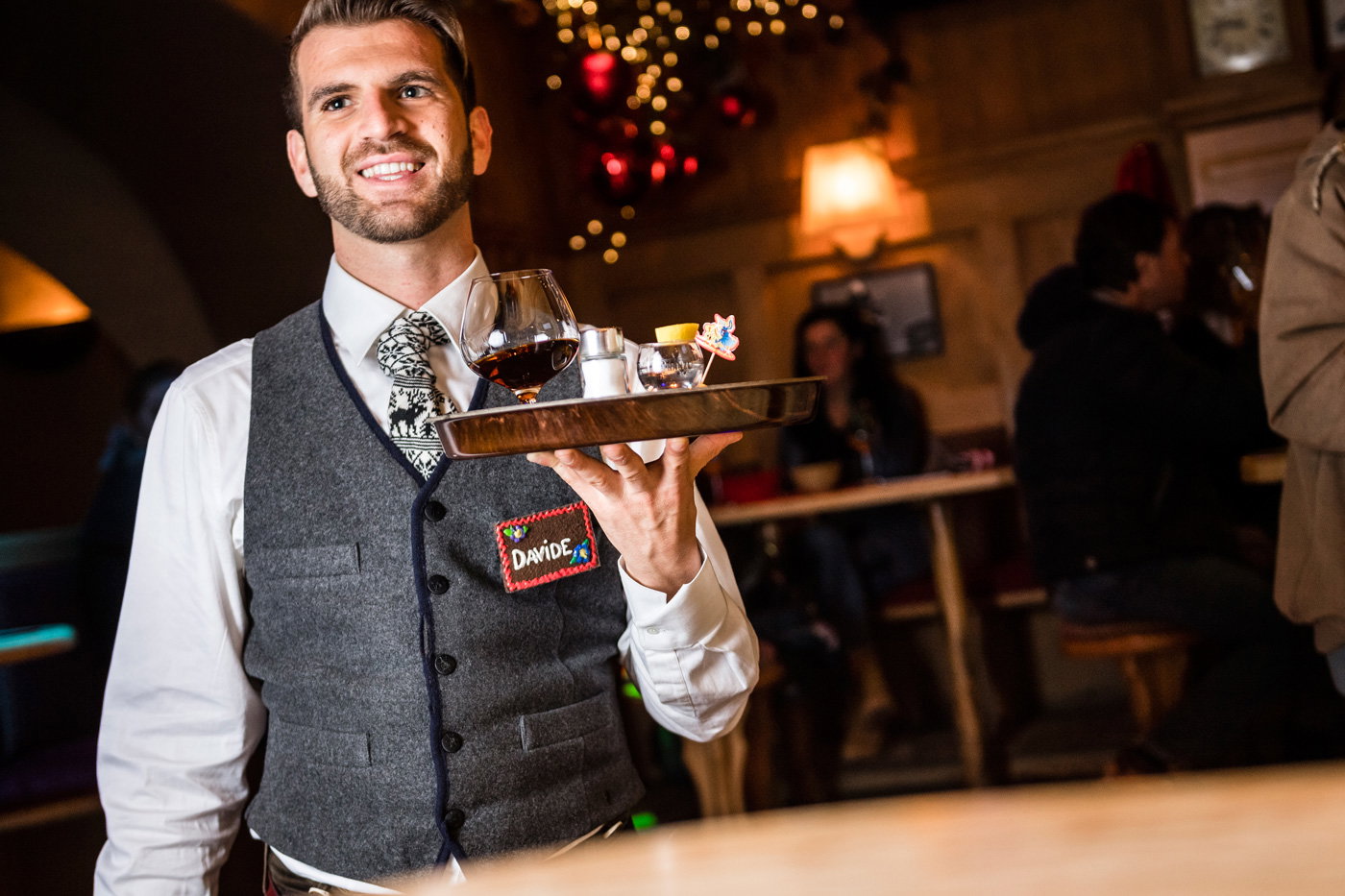 Medewerker bediening met een dienblad in een apres ski bar