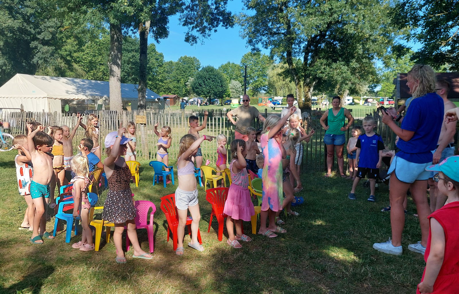 Teamleider animatie met groep kinderen op een camping