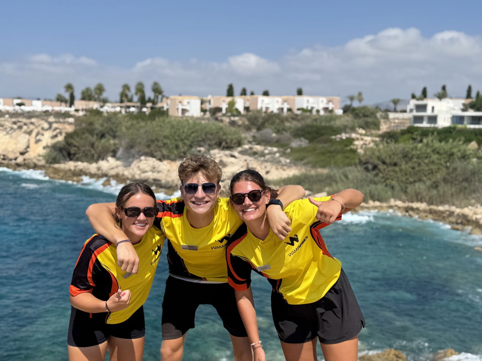 Teamfoto van entertainers met de zee op de achtergrond