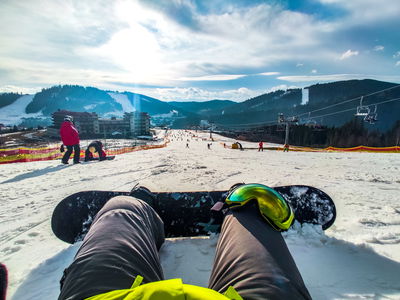 Snowboarder sits on piste with stunning view