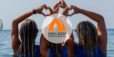 Drie vrouwen in zee die met hun handen een hart vormen