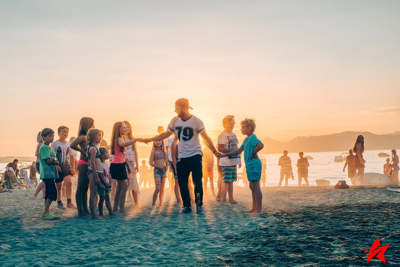 Camp-Entertainer mit Kindern am Strand
