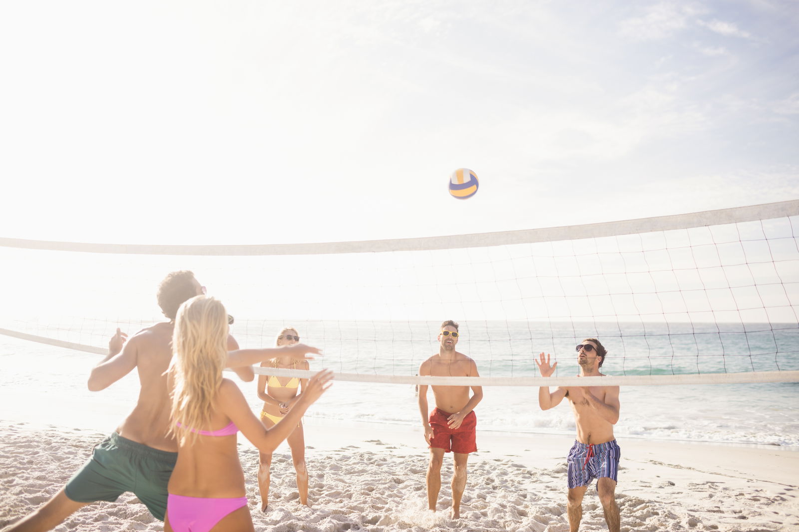 Mensen genieten op het strand en spelen volleybal 