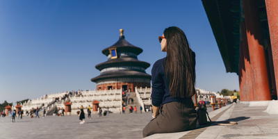Vrouw zit bij een tempel in China