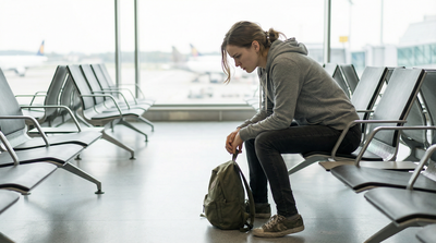 Een jonge vrouw die in een vliegtuig lounge zit